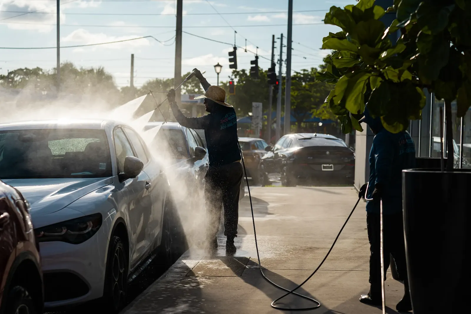 Treated water spray washing dealership vehicle